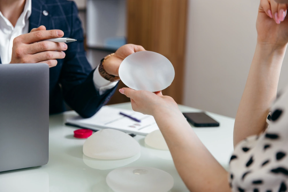 Plastic surgeon discussing breast implant options with a patient 